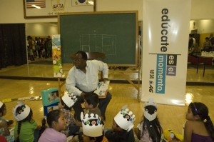 L.A. County Supervisor Mark Ridley-Thomas reads to children at Univision's Feria Es El Momento to teach families about college; photo by Joanie Harmon