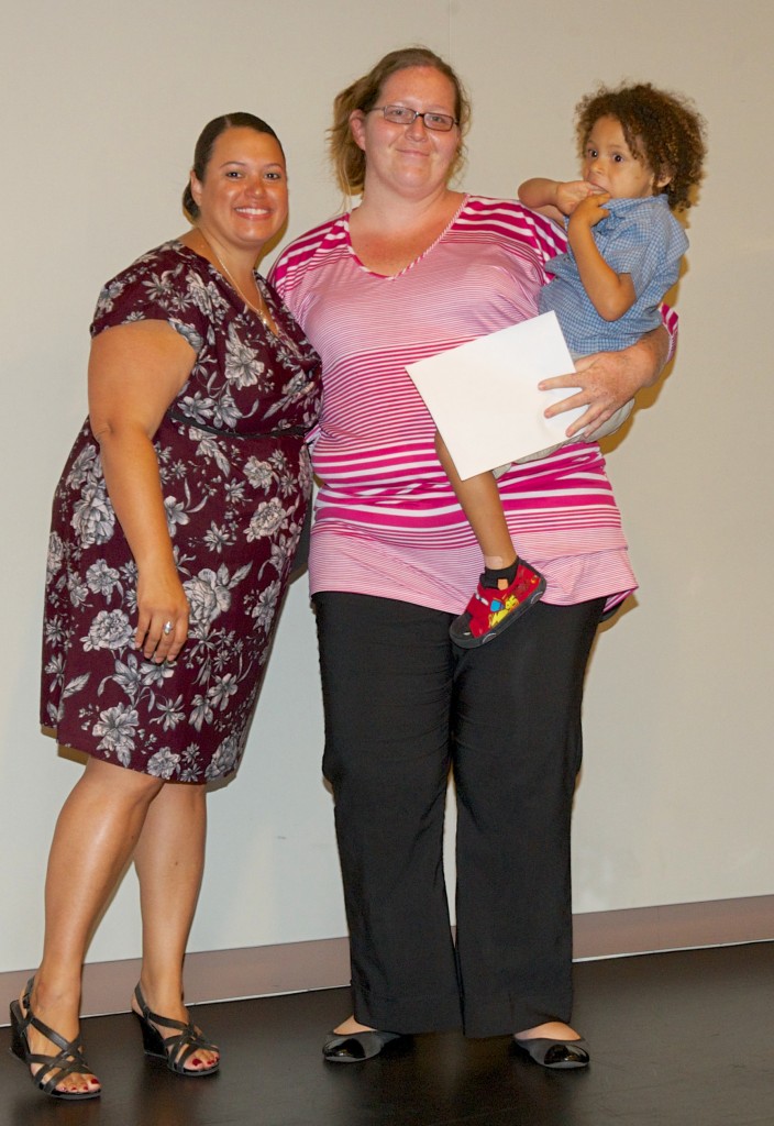 Heidi DeLeon, holding her son, receives recognition for her achievements as a McNair Scholar from the program's director Michelle Martinez.