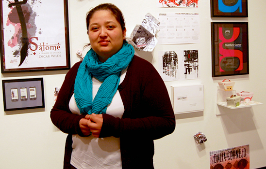 Dalia Cornejo stands by her work displayed in the University Art Gallery during the 2013 Annual Student Art and Design Exhibitions: B.A. Graduates.