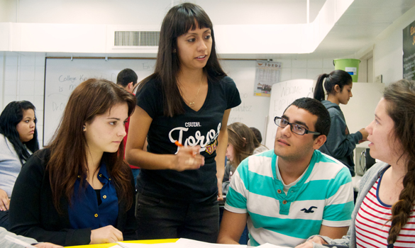 ETE Peer Mentor Laura Ramirez (standing) provides tutoring in math to ETE students.