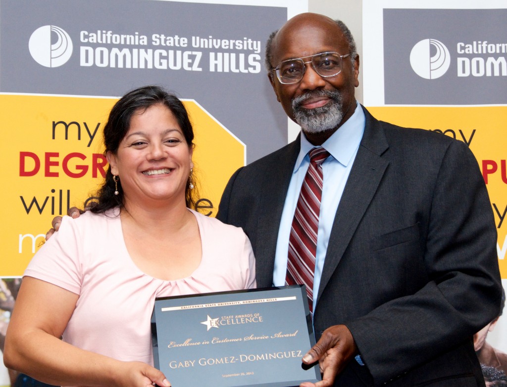 University President Willie J. Hagan presents the 2013 Staff Excellence in Customer Service Award to Gaby Gomez-Dominguez.