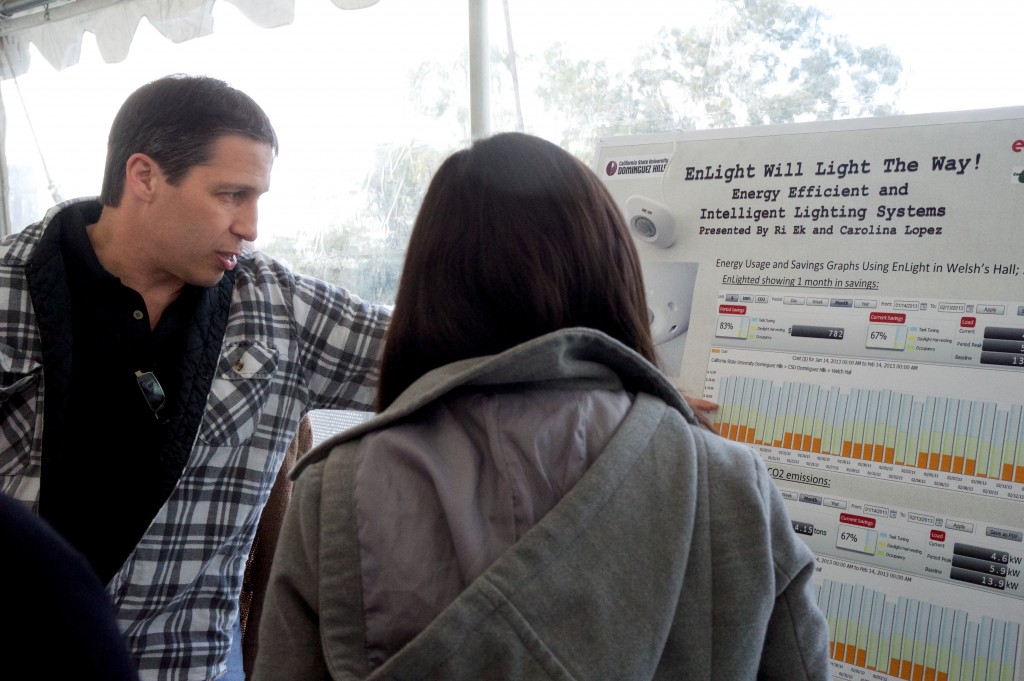 Kenny Seeton reviews lighting retrofit research findings with project researcher Carolina Lopez during the 2013 student research day.