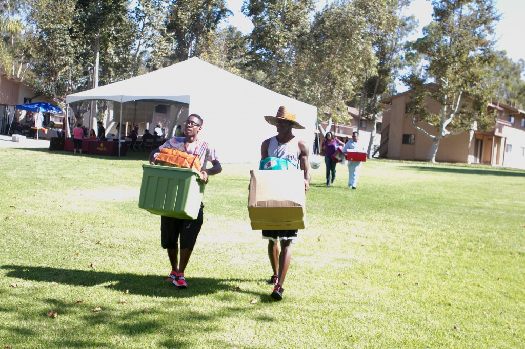 Damidre Tackwood (left) gets help from a friend carrying boxes to his new apartment on campus. Parents Dawasha and Stanley Johnson follow behind.