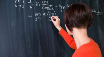 stock photo of student writing math equations on chalkboard