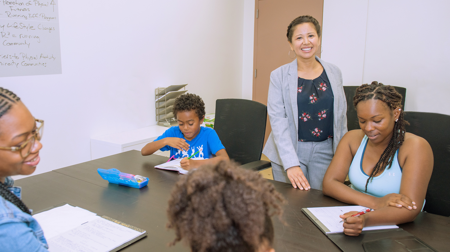 Katy Pinto, the 2019 Presidential Outstanding Professor Award recipient, works with students and their children in the Social Problems Research Laboratory. 