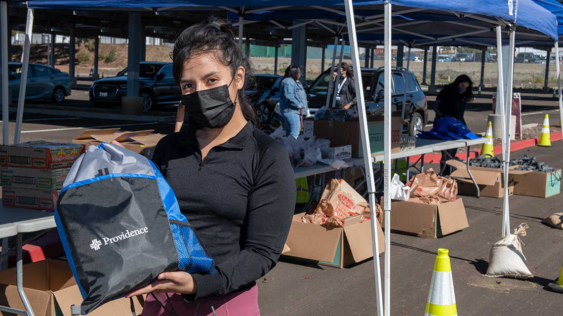 Alumna Giselle Corral, an office support specialist in CSUDH’s Toro Guardian Scholars program, helps the Toro Food Pantry distribute food and COVID-19 protection supplies to her peers.