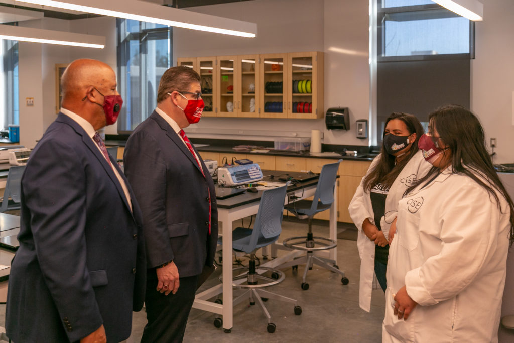 CSUDH President Thomas Parham (left) and CSU Chancellor Joseph Castro (center) speak to Center for Innovation in STEM Education (CISE) student volunteers inside the Science and Innovation Building.