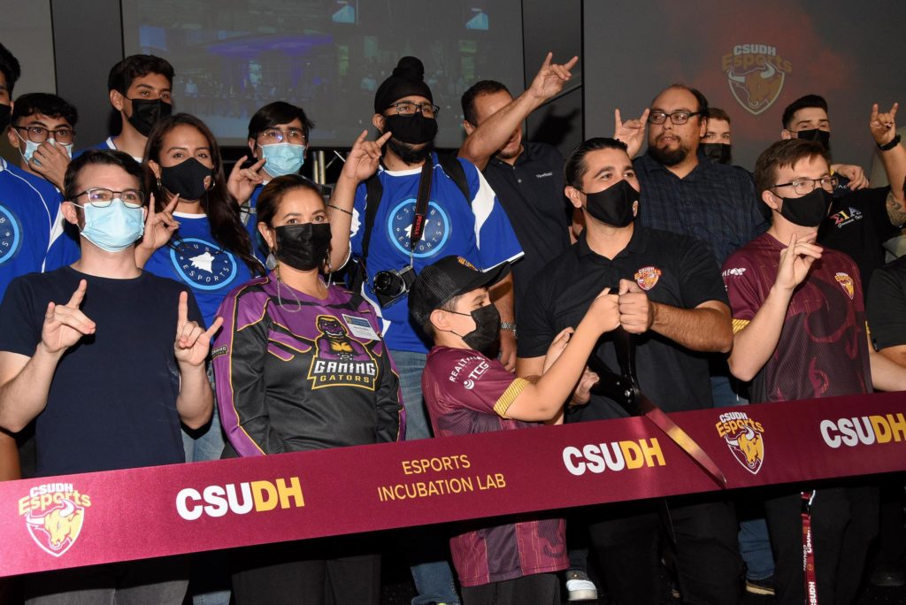 Ruben Caputo (center), director of the CSUDH Esports Association, cuts the ribbon with esports team members and supporters near the site of the new Esports Incubator Lab.