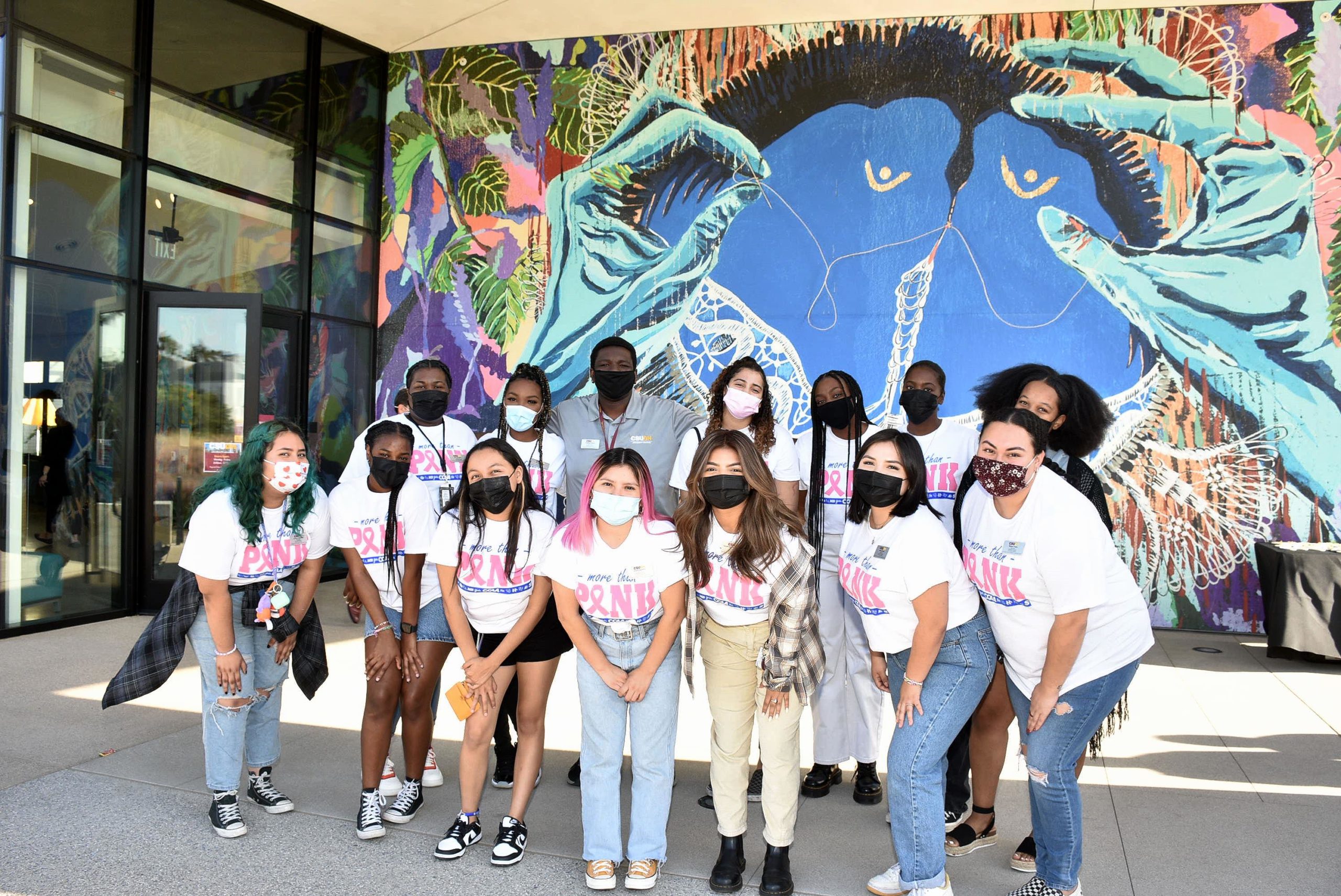 CSUDH students pose outside one of the colorful murals adorning the new Student Resident Housing complex.
