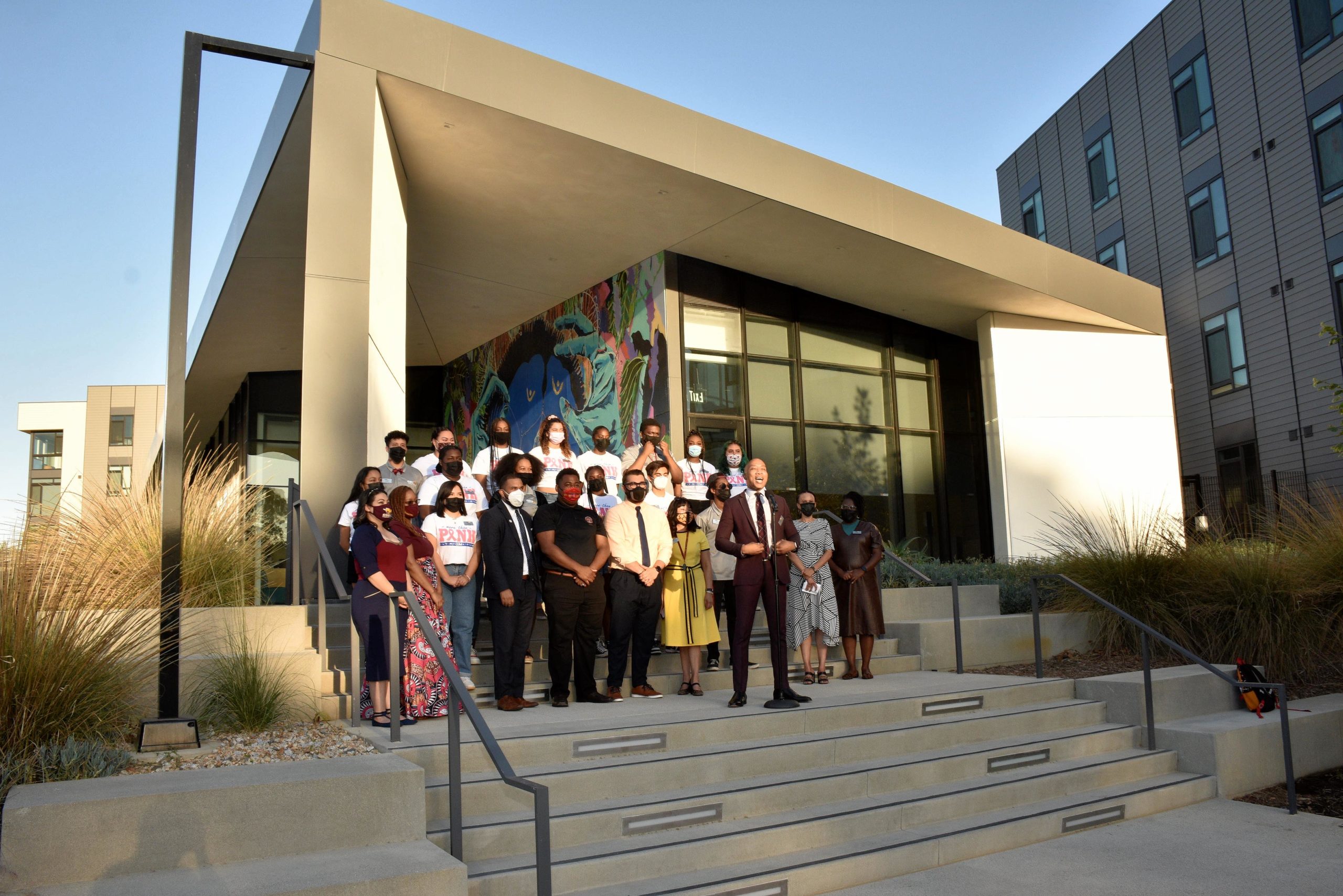 CSUDH Vice President of Student Affairs William Franklin (center-front) addresses event attendees outside the new Student Resident Housing complex.