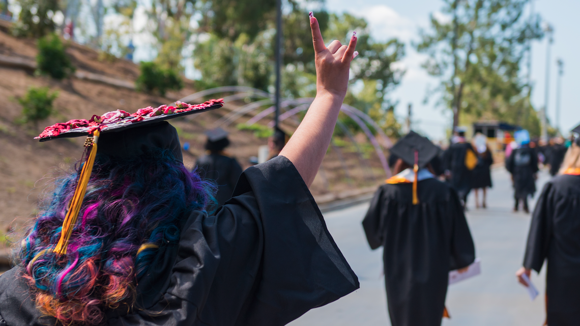 Graduating student giving Toro hand signal