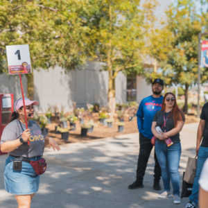 A CSUDH tour guide talks to a group of people on the east walkway.