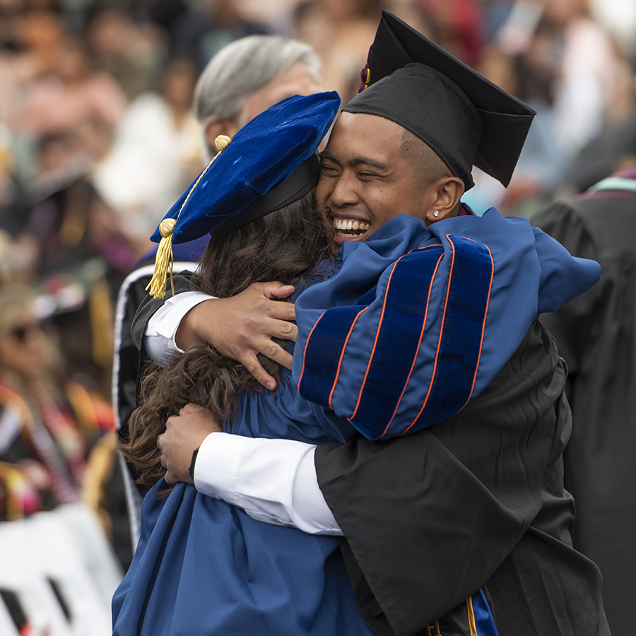 A graduate hugging a faculty member