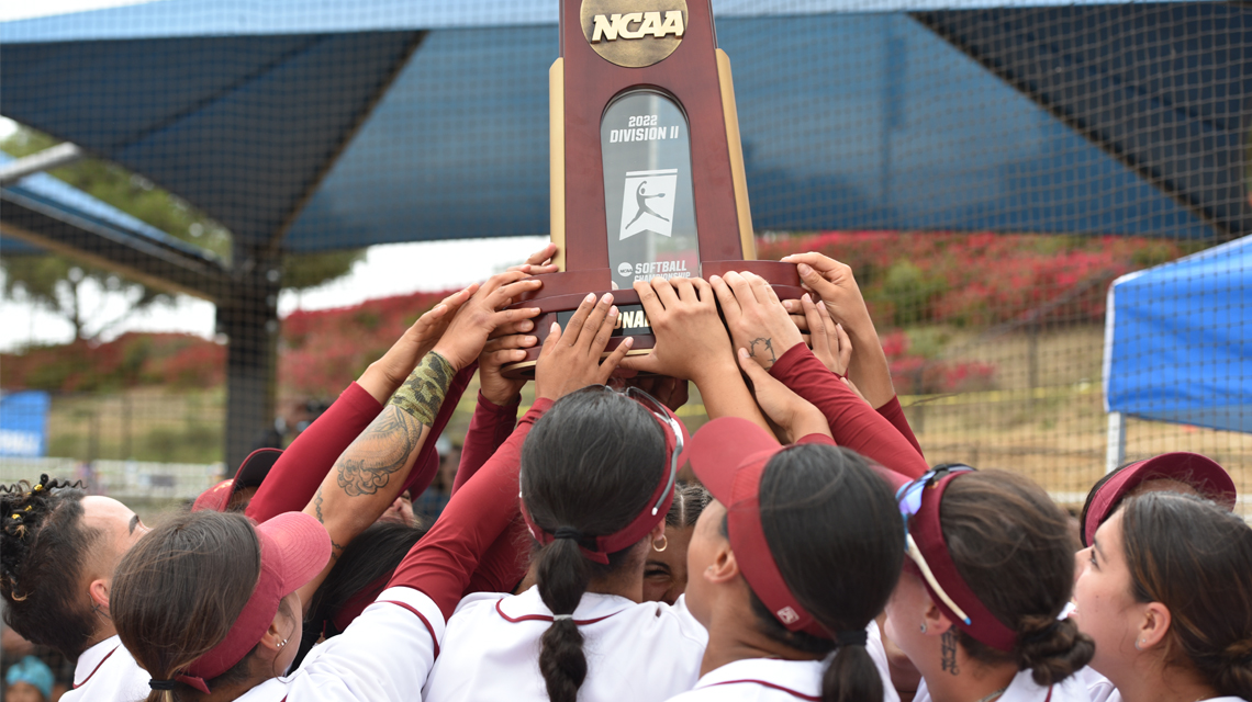 Toro softball raise the West Super Regionals NCAA Division II trophy is held high in the air.