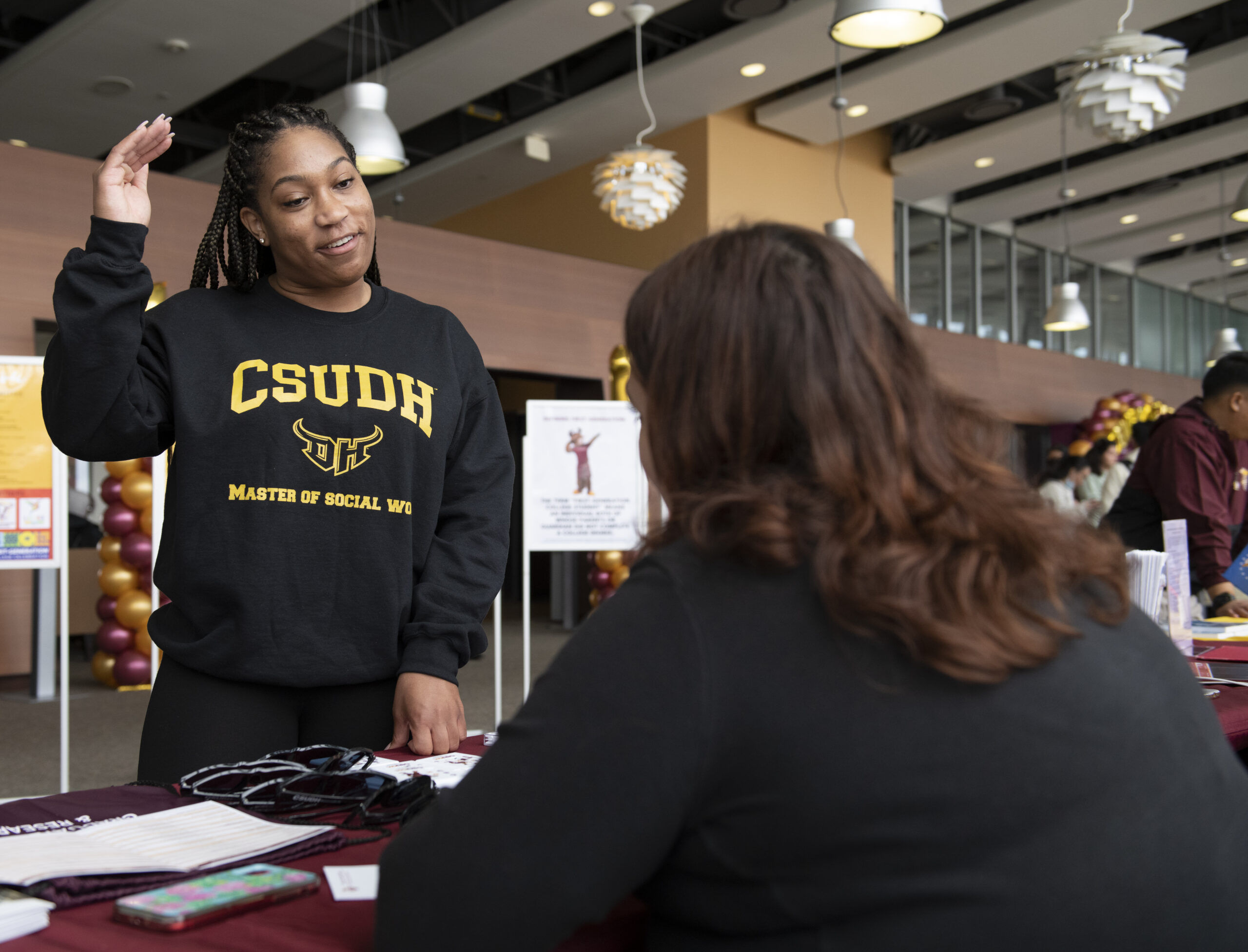 Masters of social worker student visits table at 4th annual 1st Gen student celebration