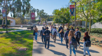 Students walking on CSUDH's East Walkway on a sunny day.