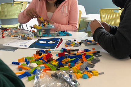 Attendees of Girls in STEAM Day use Legos to explore structural engineering.