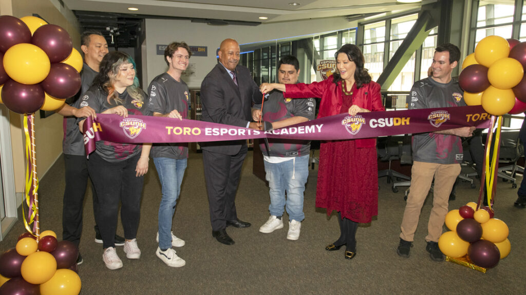 : CSUDH President Thomas A. Parham cuts the ribbon opening the Toro Esports Academy, aided by CSU Board of Trustees Chair Wenda Fong, President of the CSUDH Esports Association Franky Saldana, and others.