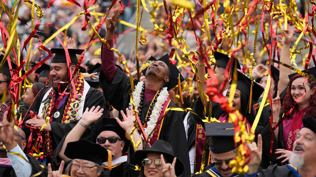 Graduates celebrate at Commencement 2023 as confetti falls on the crowd.