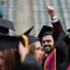 Graduate celebrating with a thumbs up at Commencement
