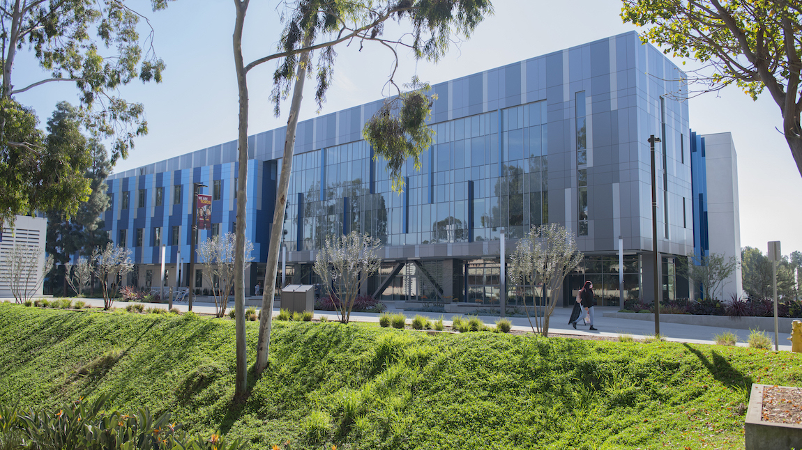 Student walking near Science and Innovation building on campus.