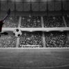 Soccer player kicking the ball in a stadium full of people