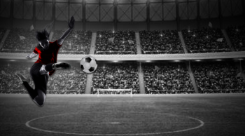 Soccer player kicking the ball in a stadium full of people