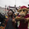 Graduate taking a selfie with Teddy the Toro