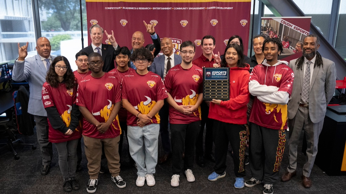 CSUDH and CSU Chancellor's Office administrators posing with the CSUDH Esports Overwatch 2 team and their plaque