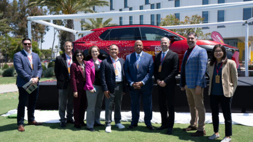 Group of leaders from Toyota and CSUDH standing in front of a newly unveiled Toyota bZ4X