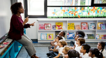 Teacher addressing classroom of young children.