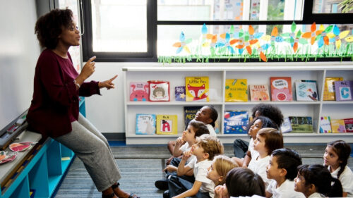 Teacher addressing classroom of young children.