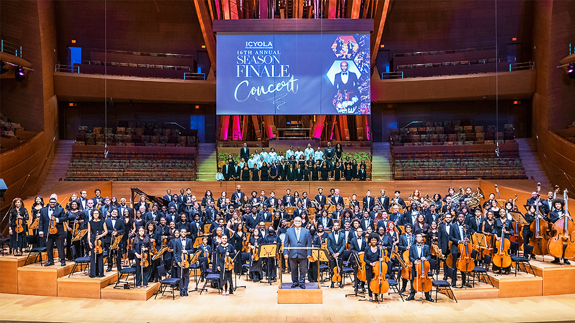 Group image of an orchestra on stage at the Kennedy Center.