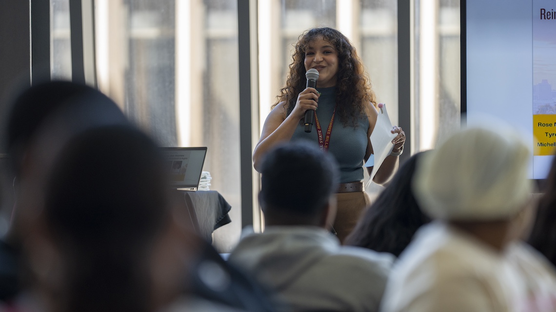 Amalia Medina Castañeda speaking in front of an audience in the University Library