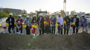 Group of people with ceremonial shovels at dig site