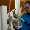 Student wearing safety goggles and working with lab equipment