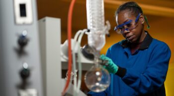 Student wearing safety goggles and working with lab equipment