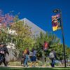 Students walking on campus underneath CSUDH banners