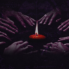 Hands encircling a lit candle