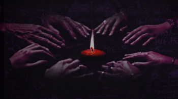 Hands encircling a lit candle