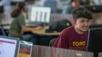 Student in Toro Nation shirt at computer