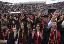 Graduates making the Toro hand sign and cheering during Commencement