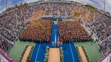 A curved aerial view of seated graduates and guests at Commencement.