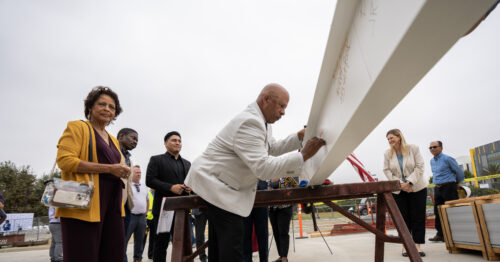 President Parham signing a metal beam