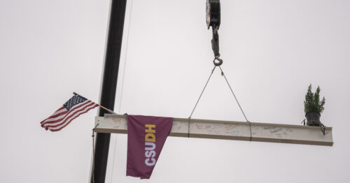 The signed beam with an American flag and CSUDH banner