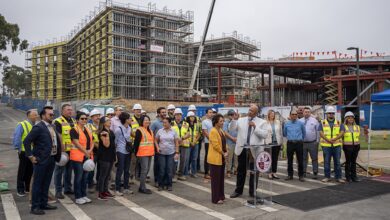 Group of university leaders and construction workers on campus building site