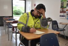 Jimmy Dominguez writing at a classroom desk