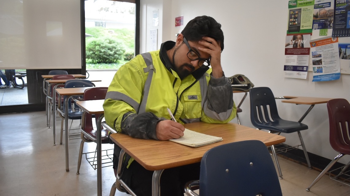 Jimmy Dominguez writing at a classroom desk