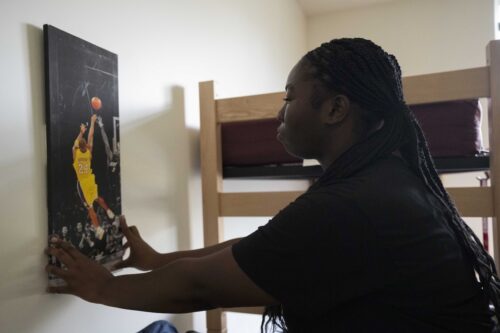 A student puts up decorations in her room.