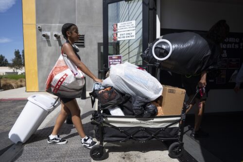 A student with a cart full of belongings on move-in day.